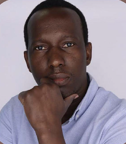 Headshot of Dramane Bationo wearing a light blue shirt with one hand placed pensively under his chin. The image is set against a grey background