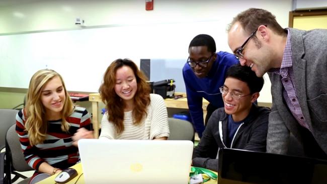 Students gathered around a laptop